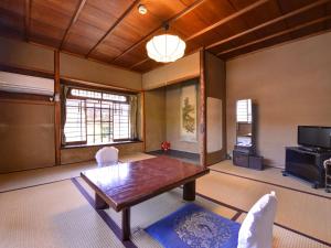 京都有效日式旅馆的客厅配有桌子和电视