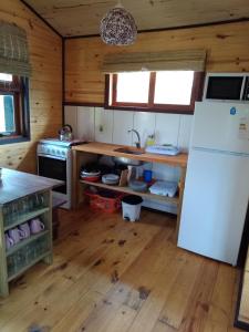 德尔迪阿布罗角UN SUEÑO LOFT的厨房铺有木地板,配有白色冰箱。