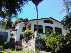 博瓦隆Elilia's Haven的前面有棕榈树的白色房子