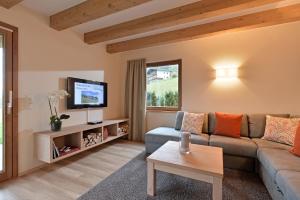 布利克森塔勒Resort Tirol Brixen am Sonnenplateau的带沙发和电视的客厅