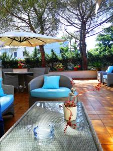 巴里Bed and Breakfast La Villa AMBIENTI SANIFICATI CON GENERATORE DI OZONO的庭院配有桌椅和遮阳伞。