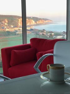 普尔维叙尔梅尔Le Tableau的客厅配有红色的沙发、桌子和咖啡杯