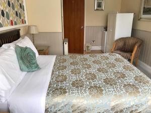 赫尔赫尔河畔京士顿饭店的一间卧室配有一张大床,上面有绿色枕头