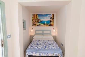 莱切省卡斯特罗Buon Vento的一间小卧室,配有一张床和墙上的绘画