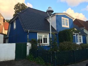 阿尔滕基兴Blue House Rügen的蓝色的房子,有黑色的屋顶和栅栏