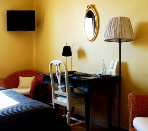 斯特兰奈斯劳伦蒂斯酒店的一间卧室配有一张桌子、一盏灯和一把椅子