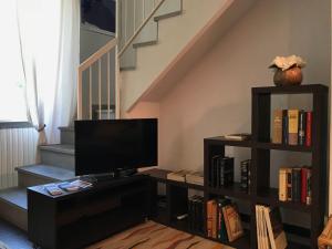 贝加莫Casa Pignolo的客厅配有电视和带书籍的书架