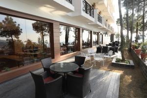 KandāghātDeventure Shimla Hills的餐厅设有桌椅和窗户。