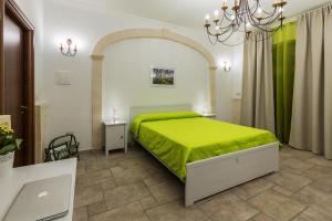 马鲁焦b&b Melina的一间卧室配有一张绿色的床和吊灯。