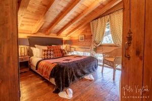 莱热Chalet Camomille的一间卧室设有一张床和木制天花板