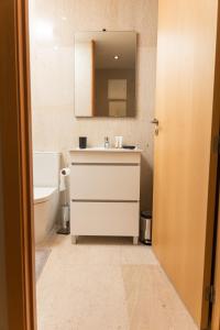 布拉加Design Flat in Braga - by TonsdeVerde的浴室配有盥洗盆、镜子和浴缸