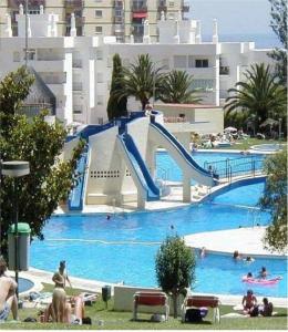 贝纳尔马德纳Estudio J-60, terraza & 1º planta的度假村内带滑梯的大型游泳池