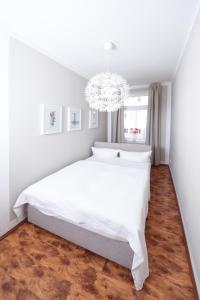 莱比锡Apartments-Leipzig的卧室配有白色的床和吊灯。