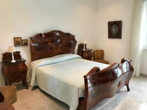 塔兰托Villa Valentina的一间卧室配有一张大床和木制床头板
