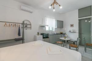 Péran TriovasálosSea Sun Sand Studios的一间厨房,里面配有白色的桌子和椅子