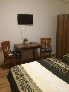 波鸿亚伯公寓的一间卧室配有一张床和一张带两把椅子的桌子
