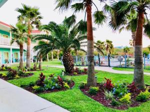 阿兰瑟斯港阿兰瑟斯港戴斯酒店的草上种有棕榈树和花卉的公园