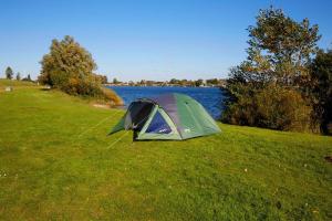 Sandavágur吉莲内斯旅舍的湖边草丛中的绿色帐篷