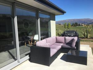 瓦纳卡尖塔岭度假旅馆的紫色沙发,坐在带窗户的庭院