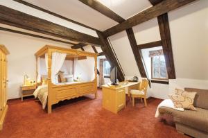罗滕堡Hotel Altes Brauhaus garni的一间卧室配有一张床和一张书桌及电视