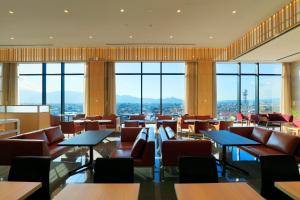 橿原市奈良橿原坎德奥酒店的餐厅设有桌椅和窗户。