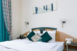 布兰肯贝赫Hotel Moby Dick by WP hotels的一间卧室配有一张带白色和绿色枕头的床