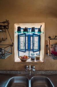 Ţabaqat FaḩlBeit Al Fannan的厨房水槽和蓝色窗户