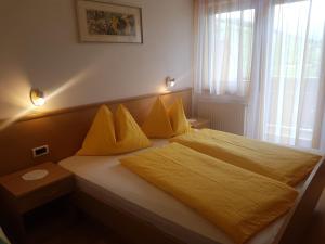 马兰扎Ferienwohnung Winklerhof的一间卧室配有一张带黄色床单的床和一扇窗户。