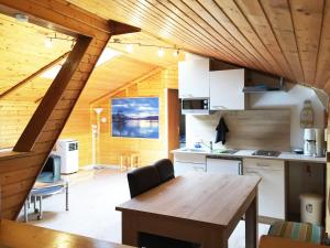 法克湖Karawanken Lodge的厨房设有木制天花板和木桌。
