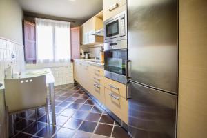 Posada de LlanesBuga II的厨房配有不锈钢冰箱和水槽
