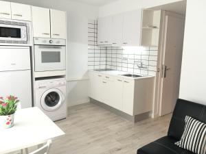 布拉内斯Aiguaneu Sa Carbonera的厨房配有白色橱柜、洗衣机和烘干机