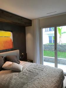 阿斯科纳Appartement Suite Delta Resort的一间卧室设有一张床和一个大窗户