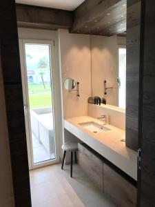 阿斯科纳Appartement Suite Delta Resort的一间带水槽、镜子和凳子的浴室