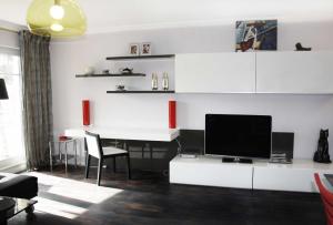 巴特萨罗皮斯库夫Residenz "Zum Kronprinzen" Wohnung Nr.10的客厅配有书桌和电视。