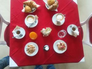 阿维亚诺Villa Marini Trevisan的红色桌子,上面有早餐食品和咖啡