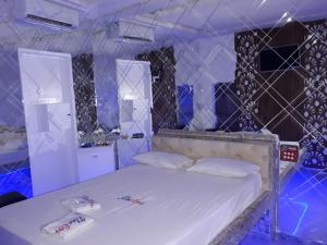 阿拉卡茹Motel Flex Love (Adults Only)的蓝色的客房配有带白色床单和枕头的床。