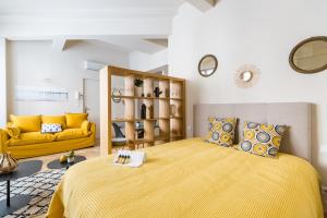 波尔多Les Suites de Saint Amand的一间卧室配有黄色的床和黄色的沙发