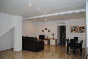 圣卡洛斯拉腊皮塔Apartaments el tiet的客厅配有黑色沙发和桌子