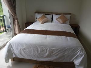 范县Supunnika Garden Guesthouse的一间卧室配有带白色床单和枕头的床。