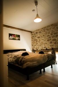 库万Gîtes du tellin的一间卧室设有一张床和石墙