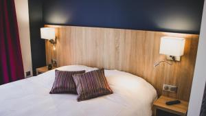 拉昂Hôtel du Tramway的一间卧室配有一张带两个枕头的床