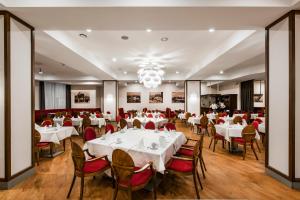 克莱佩达克莱佩达艾伯顿酒店的餐厅配有白色的桌椅和吊灯