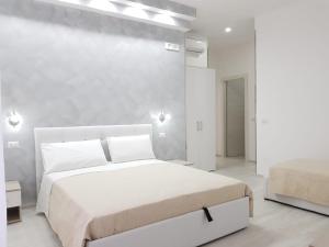 维耶斯泰Dream & Relax的白色卧室设有两张床和一堵墙