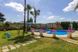 拉卡莱Villa Full'House的后院设有棕榈树游泳池