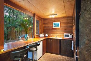 拜伦湾戈可谢德旅馆的厨房配有带水槽的柜台和窗户。
