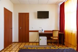 秋明Hotel Agat的酒店客房设有一张桌子和一台墙上的电视