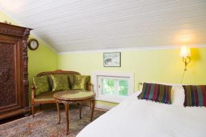 Lohja科伊瓦伦卡塔诺酒店的一间卧室配有一张床、一把椅子和一张桌子