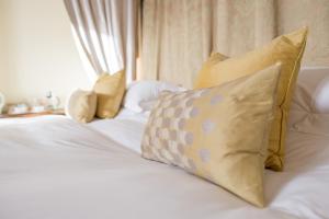 伦敦The Bockery Suite 2 Chelsea的一张白色的床,上面有黄色枕头