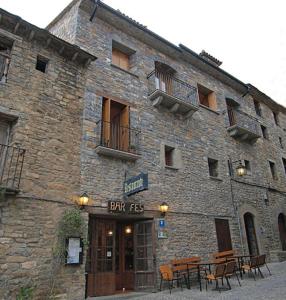 艾因萨Casa Fes Autural的一座石头建筑,前面设有桌椅