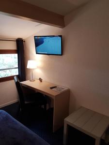 比斯卡罗斯海滩莱斯杰迪斯德乐奥酒店的酒店客房设有一张桌子和一台墙上的电视。
